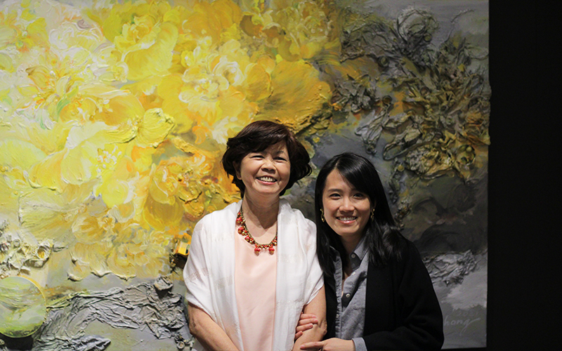 Two women in front of a large painting