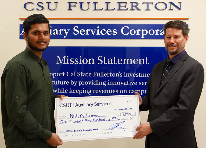 Nithish receives a check worth $1,500 from ASC Executive Director Charles Kissel