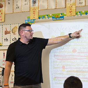 Elementary school teacher pointing at whiteboard