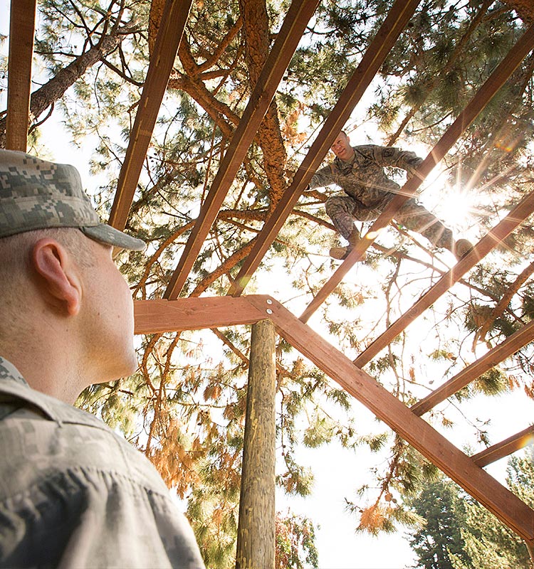 ROTC cadet looking at another cadet on exercise structure