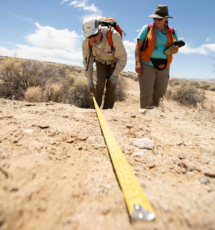 Researcher measures surface rupture with tape measure