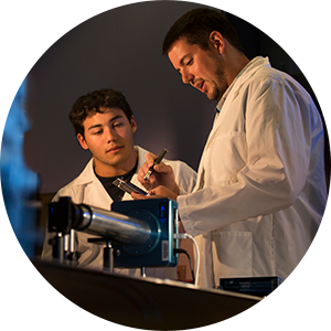 Faculty member and student look at lab equipment