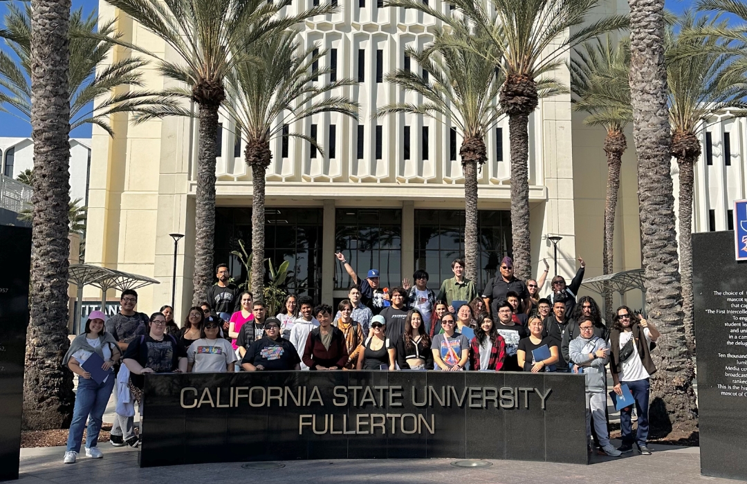 Transfer students standing behind Cal State Fullerton sign