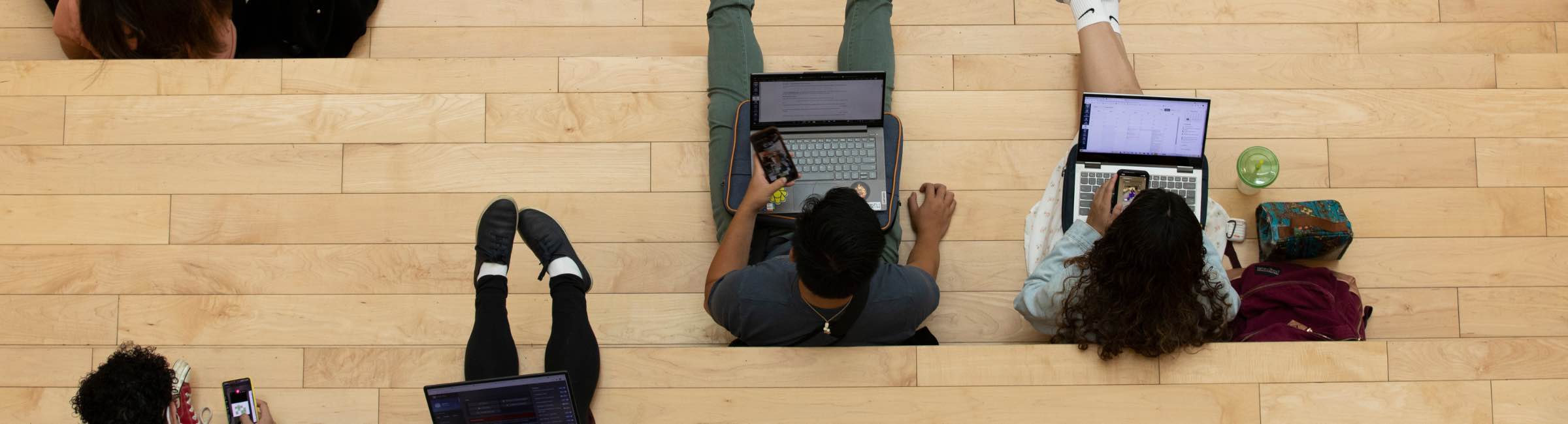 Students sitting down using technology devices